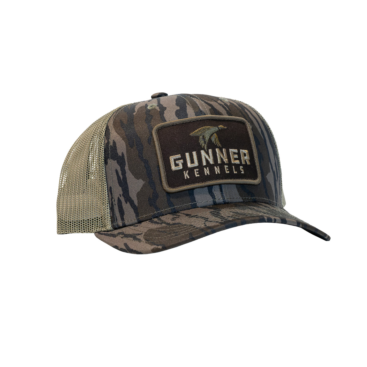 BOTTOMLAND MALLARD TRUCKER hat in Mossy Oak pattern with a tan mesh back and a rectangular patch on the front featuring a duck silhouette above the text GUNNER KENNELS.