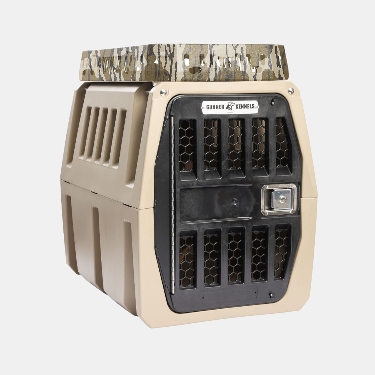 A tan GUNNER dog kennel featuring a black metal door, side ventilation slats, and a camouflage-patterned lid sits at the front with a Gunner Kennels logo and silver latch—ideal for use with your Kennel Rack - Mossy Oak Bottomland to create an organized dog storage system in your truck bed.