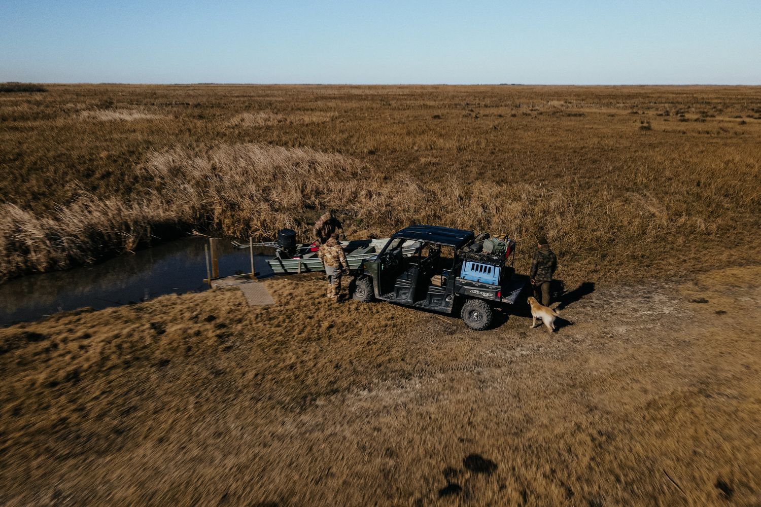 Limited-edition Anahuac G1™ Kennel on a Can-Am in Anahuac, Texas. Waterfowl hunters and a yellow Labrador Retriever stand around the vehicle.