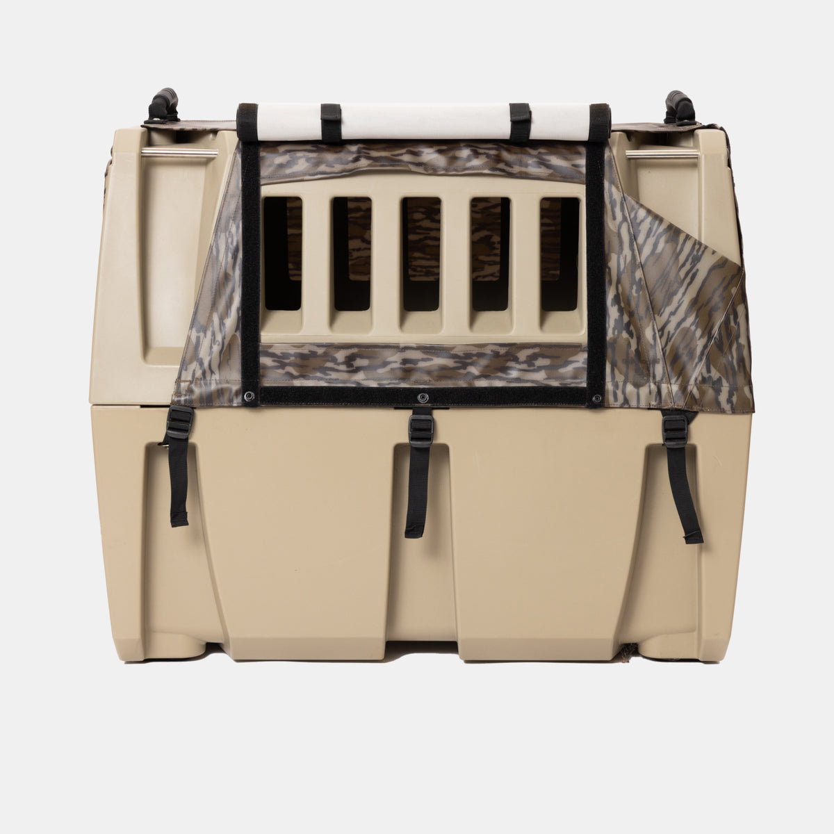 A GUNNER pet crate is shown with the ALL-WEATHER KIT 2.0 MOSSY OAK BOTTOMLAND waterproof cover partially draped over the front, featuring a camouflage pattern and black securing straps. The beige crate includes vertical ventilation slats and a solid base, displayed against a plain white background.