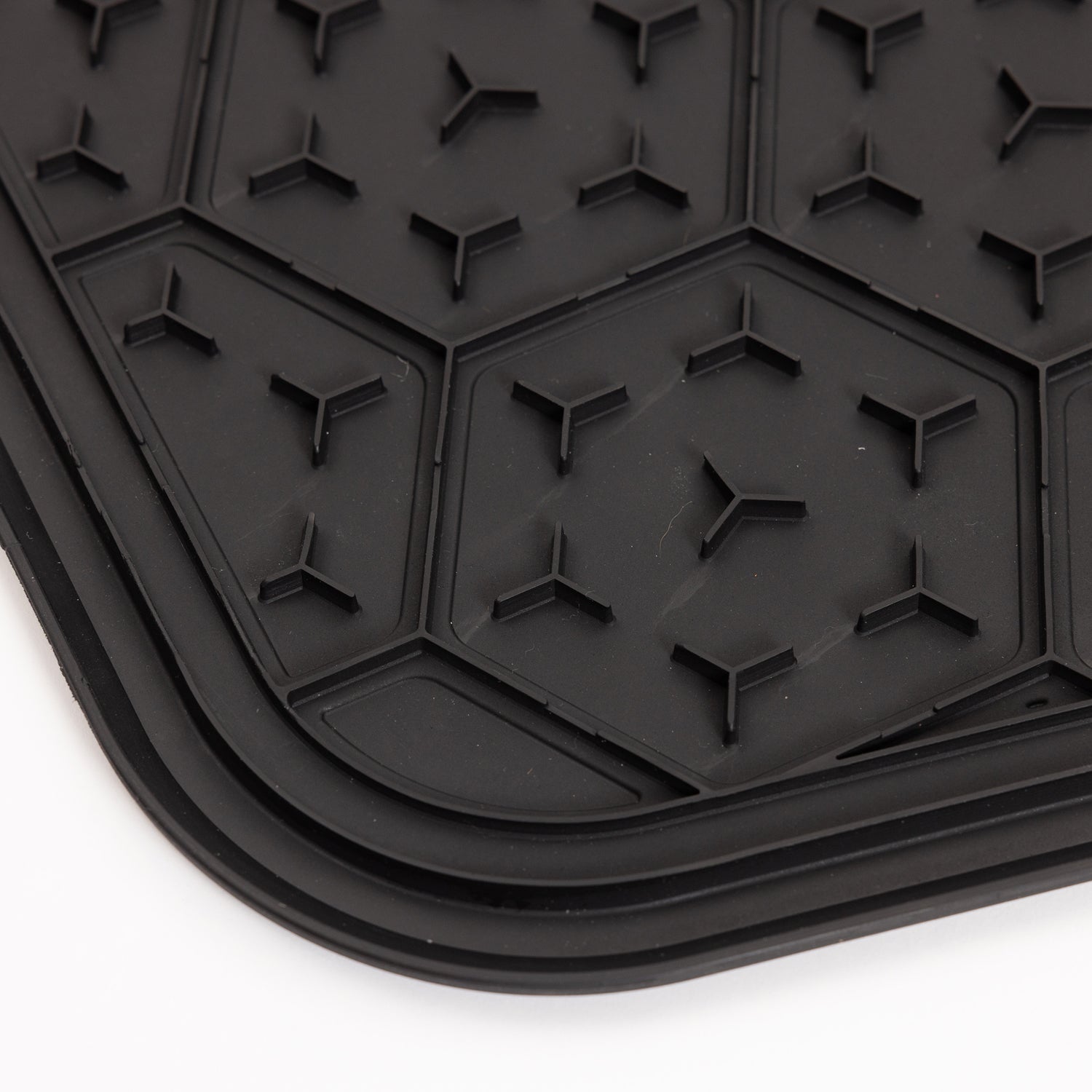 Close-up of the GUNNER BOWL MAT - BLACK, a slip-resistant black rubber mat featuring a hexagonal pattern with small raised triangular shapes, displayed on a white background.