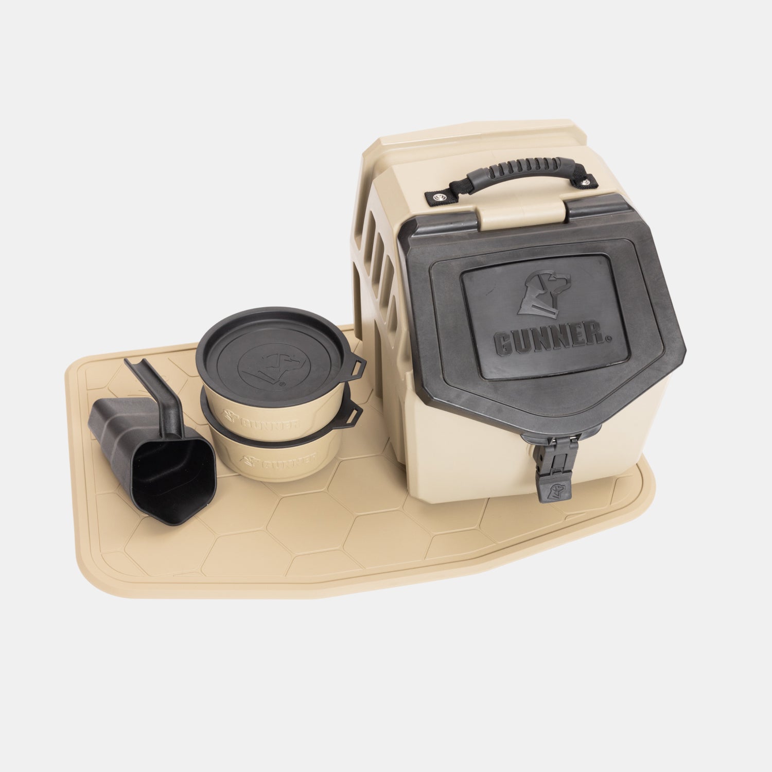 Displayed on a white background is the GUNNER BOWL MAT - TAN, accompanied by beige and black pet food storage containers with handles, two stackable dishwasher-safe bowls, a scoop, and a matching slip-resistant bowl mat.