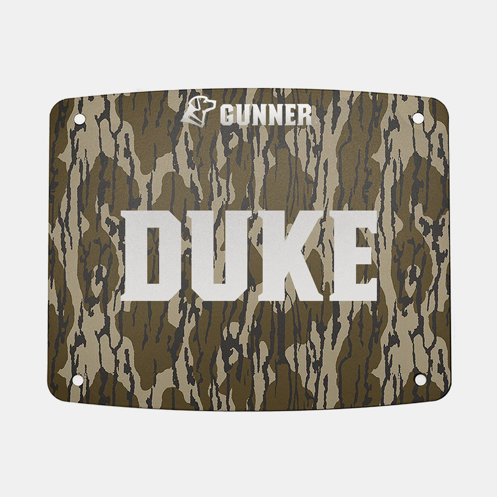 Rectangular camouflage-patterned FOOD CRATE NAME PLATE by GUNNER, featuring large white “DUKE” text in the center and “GUNNER” with a dog icon above it. Designed for personalizing your GUNNER Food Crate, this name plate includes four corner holes for easy mounting.