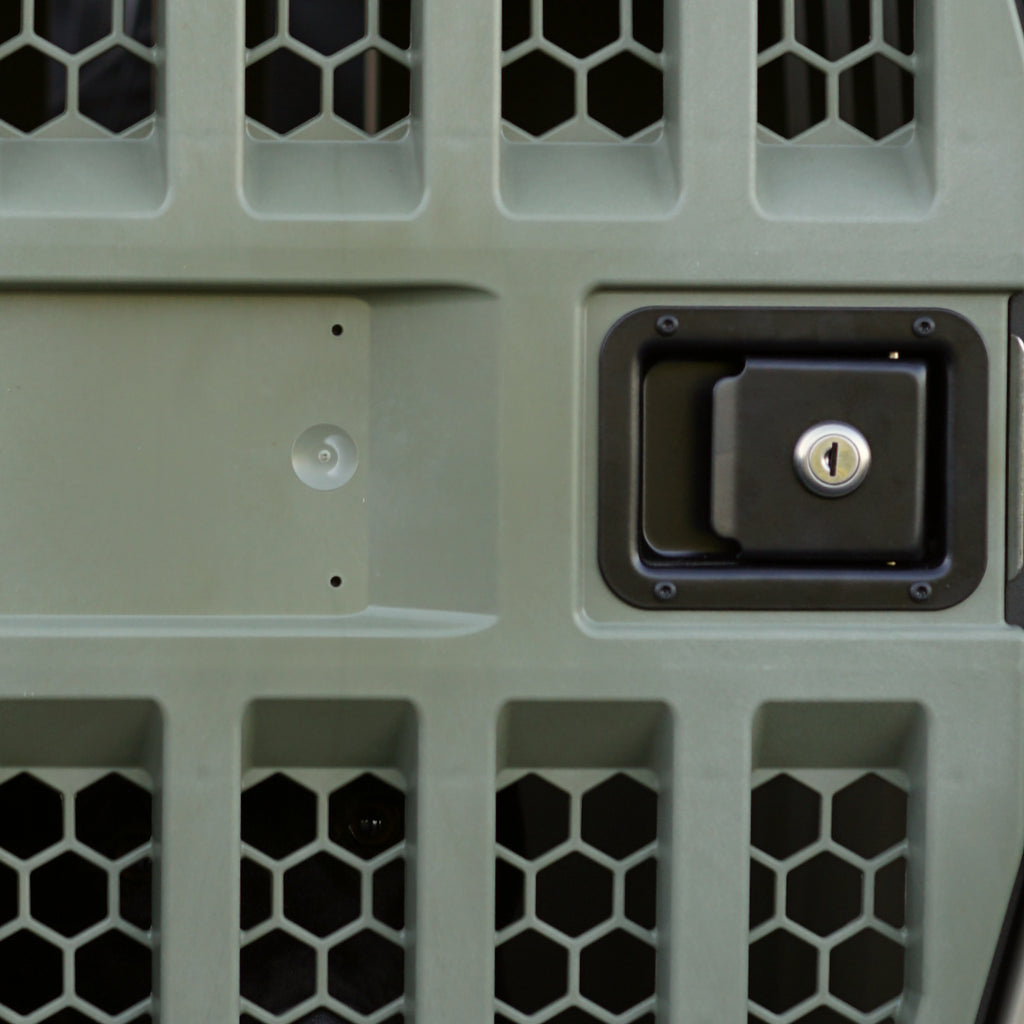 Close-up of the GUNNER G1™ KENNEL DOOR GREEN, featuring a hexagonal mesh pattern, rectangular recessed handle with keyhole, and a circular indentation with two screw holes. Ideal replacement door for your kennel.