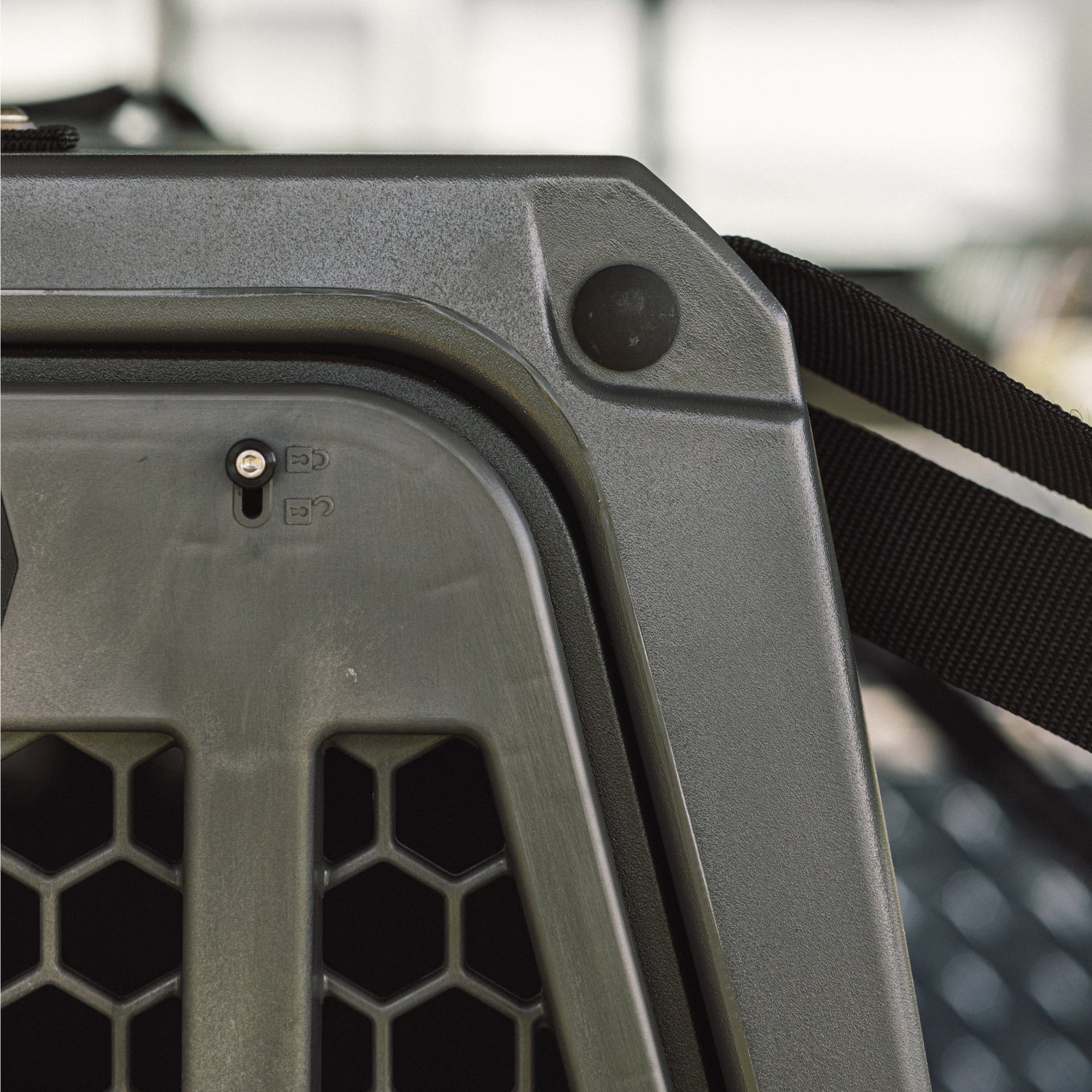 Close-up of the G1™ KENNEL - FLINT by GUNNER, highlighting its durable plastic, black strap, honeycomb-patterned ventilation holes, and latch—crafted for unmatched reliability.
