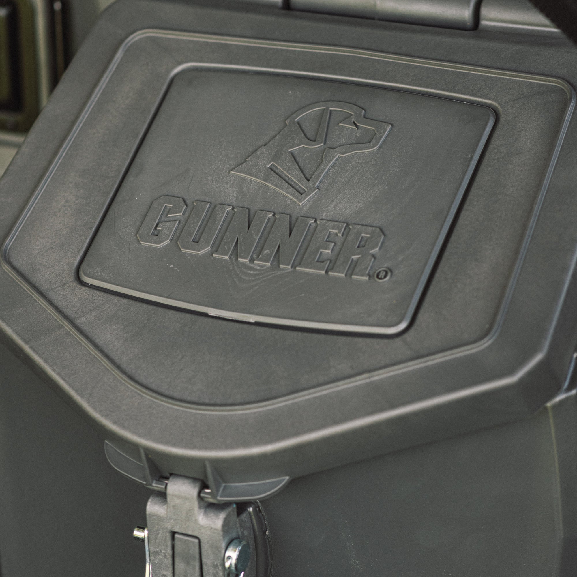 Close-up of the GUNNER FOOD CRATE - FLINT by GUNNER, showing its black lid with an embossed dogs head above the logo. This airtight food container features sturdy hinges and secure latches.