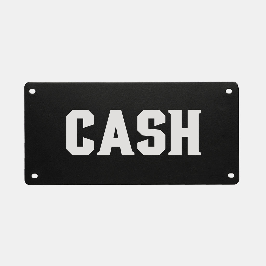 A black rectangular PERSONALIZED KENNEL NAME PLATE from GUNNER featuring the word CASH in bold, white, uppercase letters. Four pre-drilled holes—one in each corner—make this name plate easy to mount, making it a perfect custom touch for your GUNNER dog crate.