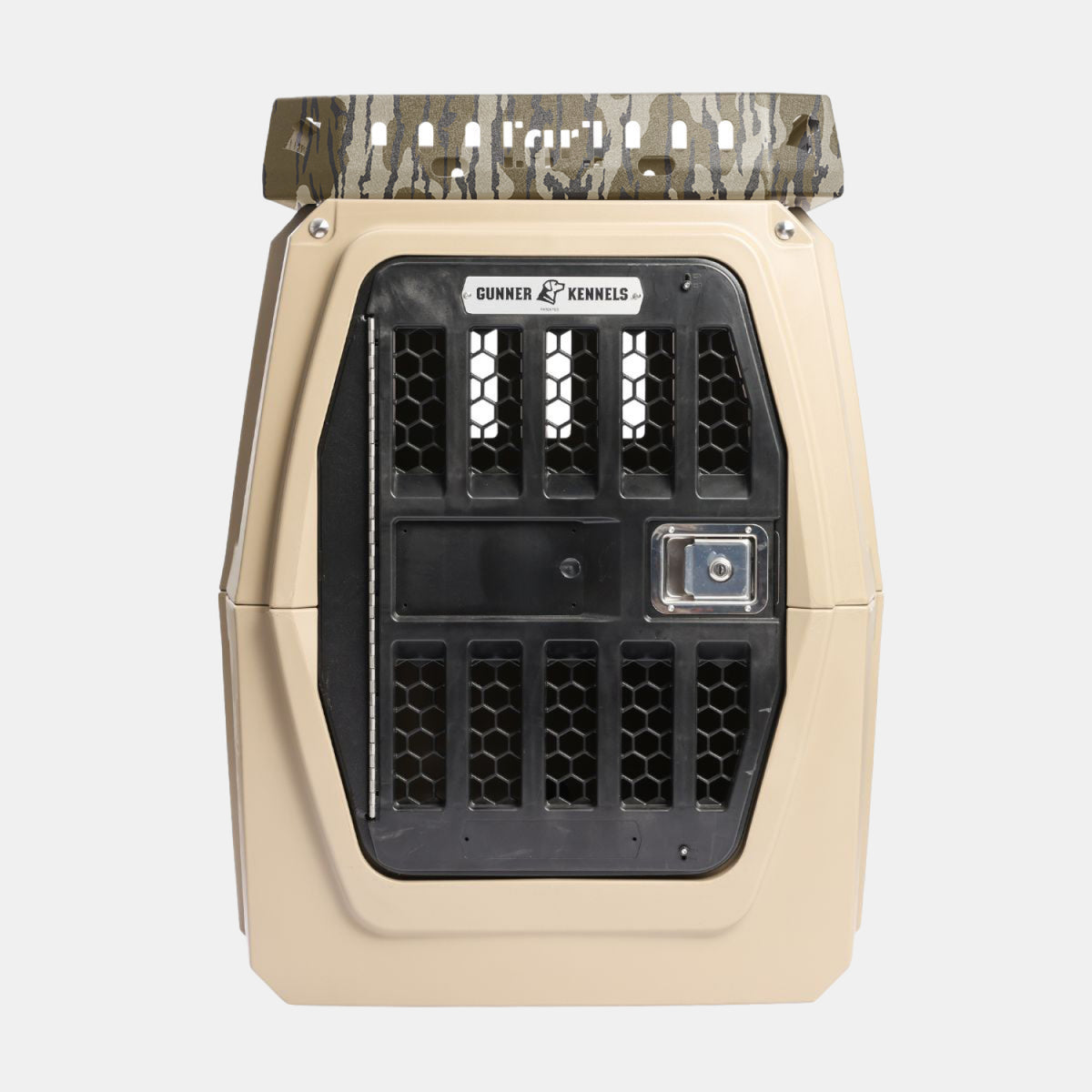 Tan and black hard-sided GUNNER Kennel Rack in Mossy Oak Bottomland, featuring a secure metal door, black ventilation slots, and a camouflage-patterned handle on top. The front displays the Gunner Kennels logo above the door. Designed to fit seamlessly with your GUNNER kennel storage system, this kennel rack maximizes your truck bed space while keeping your pet safe and comfortable for every adventure.