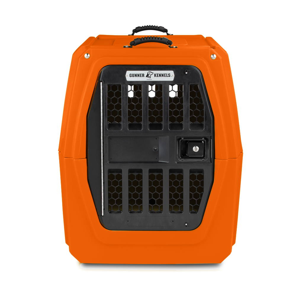 The GUNNER G1™ KENNEL - BLAZE ORANGE features a black metal door, hexagonal ventilation holes, a top handle, and a signature label above the door, all shown against a plain white background.
