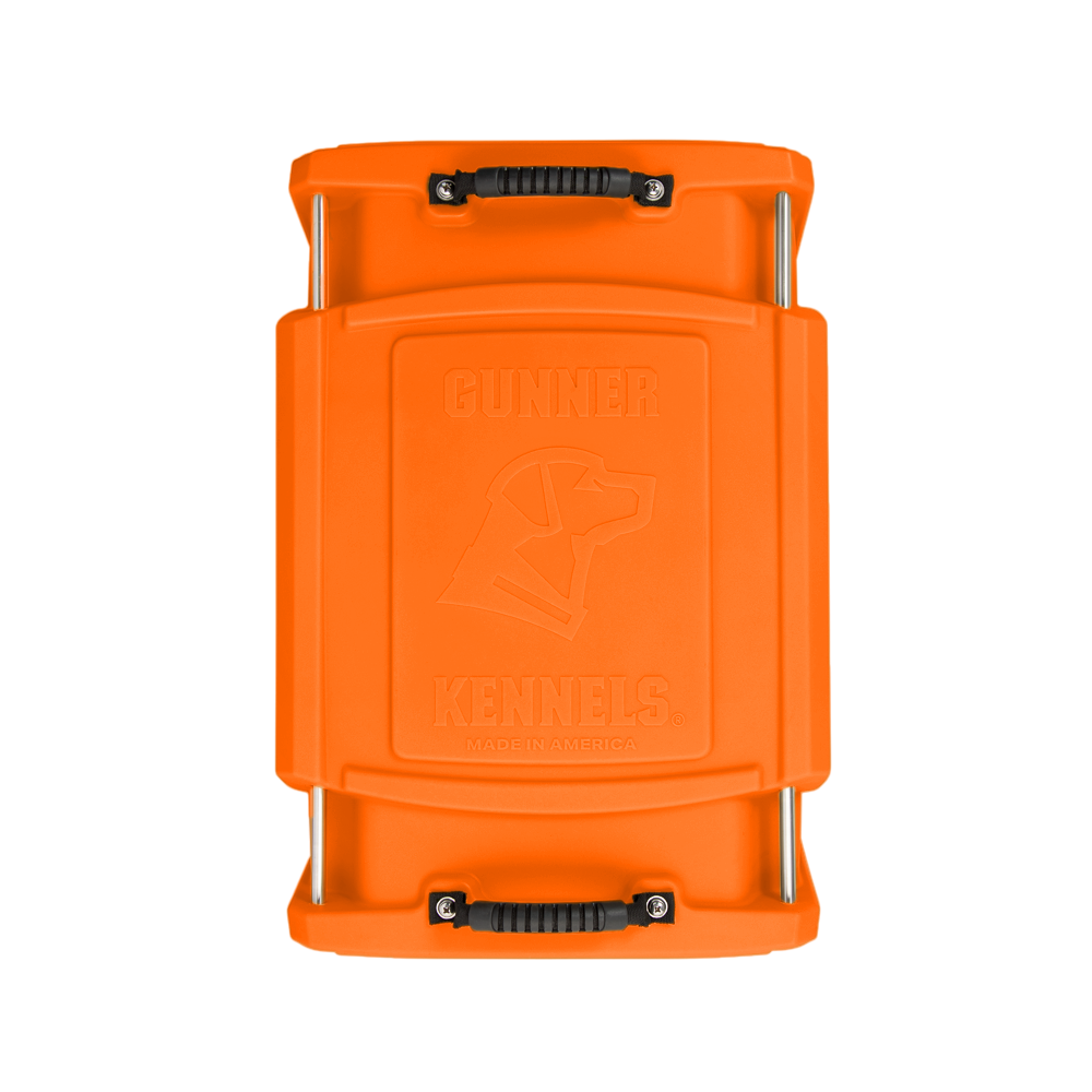Top view of the GUNNER G1™ KENNEL in Blaze Orange, showing two black carrying handles and an embossed dogs head outline with Gunner Kennels on the lid.